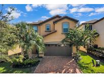 Two-story house with a brown garage door and brick driveway at 1913 Nice Ct, Kissimmee, FL 34747
