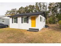 Newly renovated home with white exterior, yellow door, and gray accents at 1913 Nw 12Th St, Ocala, FL 34475