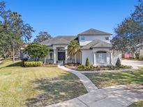 Two-story house with gray roof, white walls, and a landscaped lawn at 8019 Langhurst Ct, Orlando, FL 32835