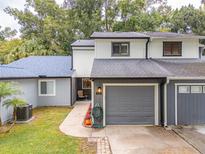 Two-story townhome with gray siding, gray garage door, and landscaped walkway at 844 Sugar House Dr, Port Orange, FL 32129