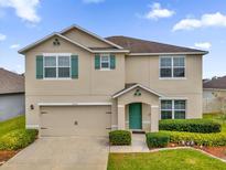 Two-story house with a green door and landscaping at 14031 Willow Grace, Orlando, FL 32824