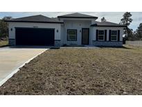 Newly constructed home with a modern design, two-car garage, and a low-maintenance yard at 16674 Sw 25Th Ct, Ocala, FL 34473