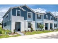 Two-story townhome with blue siding, gray roof, and a small front yard at 2432 Dubai St, Kissimmee, FL 34747