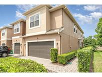 Tan two-story house with a brown garage door and manicured landscaping at 250 Merry Brook Cir, Sanford, FL 32771