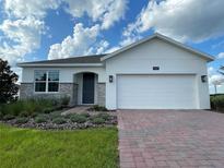 Beautiful single-story home featuring a paver driveway and landscaped front yard at 27469 Black Kite Ave, Howey In The Hills, FL 34737