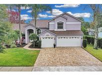 Two-story house with a light purple exterior, a brown roof, and a brick driveway at 4549 Saddleworth Cir, Orlando, FL 32826