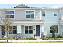 Two-story light blue townhome with gray accents and landscaping at 627 Bayhawk St, Debary, FL 32713