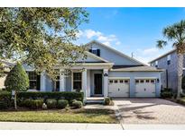 Beautiful two-story home with a light blue exterior, two-car garage, and well-manicured landscaping at 8547 Bayview Crossing Dr, Winter Garden, FL 34787