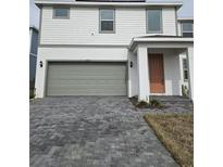 Two-story home with gray garage door and orange front door at 1603 Gardiner St, Haines City, FL 33844