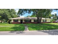 Charming single-story home featuring a brick facade, red shutters, and a well-maintained front lawn at 4131 Yorketowne Rd, Orlando, FL 32812