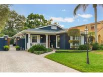 Charming blue home with white trim, landscaping, and paved driveway at 512 E Gore St, Orlando, FL 32806