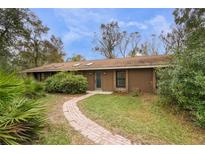 Ranch style home with brick pathway, surrounded by lush landscaping at 8045 Happy Trl, Kissimmee, FL 34747