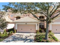 Charming home featuring a two-car garage, brick driveway, beige exterior and tile roof at 8407 Riverdale Ln, Davenport, FL 33896