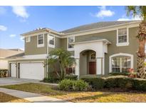 Two-story house with a two-car garage, landscaping, and a large front yard at 8511 La Isla Dr, Kissimmee, FL 34747