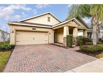 Brick paved driveway leads to a charming house with a two-car garage at 10060 Pecan Hickory Way, Orlando, FL 32832