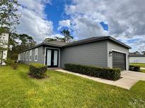 Gray house exterior with a two-car garage and well-manicured lawn at 11141 Green Citron Aly, Winter Garden, FL 34787