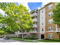 Condominium building featuring private balconies, lush landscaping, and convenient covered parking at 1211 Stonecutter Dr # 206, Celebration, FL 34747