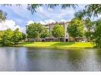 Luxury condo building with pond and lush landscaping at 1211 Stonecutter Dr # 206, Celebration, FL 34747