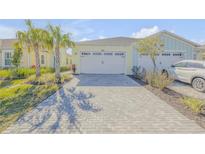 Two-story home with attached two-car garage and landscaped yard at 906 Coral Reef Way, Daytona Beach, FL 32124