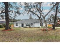 Newly renovated home with fresh white exterior and landscaped yard at 1633 Cedar Glen Dr, Apopka, FL 32712