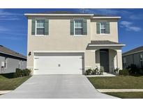 Two-story house featuring a white garage door and green shutters at 1705 Frogmore Ave, Haines City, FL 33844