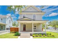 Charming two-story home with a covered front porch, beautiful landscaping, and a well-maintained lawn at 219 Laurel Ave, Sanford, FL 32771