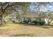 Charming single-story home with mature trees, manicured shrubs, and a well maintained lawn at 36502 Barrington Dr, Eustis, FL 32736