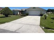 Single-story house with driveway and landscaped yard at 517 Cardinal Dr, Kissimmee, FL 34759