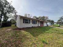Brick and stucco ranch home with a carport and spacious yard at 990 Liskeard Ave, Orange City, FL 32763
