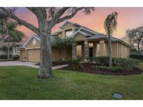 Two-story house with a three-car garage and landscaped yard at 1395 Legendary Blvd, Clermont, FL 34711