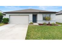 Single-story home with attached garage and well-manicured lawn at 309 Citrus Isle Loop, Davenport, FL 33837