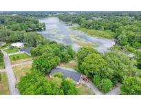 Aerial view of a house near a lake with lush green trees at 3645 Mirror Lake Dr, Apopka, FL 32703