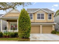 Two-story home with a manicured front yard, two-car garage, and charming front porch at 4220 Cleary Way, Orlando, FL 32828