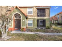 Two story condo building with Spanish tile roof and screened balcony at 445 Fountainhead Cir # 164, Kissimmee, FL 34741