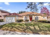 One-story house with a brown roof, attached garage, and well-manicured lawn at 7895 Saint Giles Pl, Orlando, FL 32835