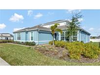 Charming single-story home featuring a light blue exterior, white trim, and lush landscaping at 15913 Winding Bluff Dr, Montverde, FL 34756