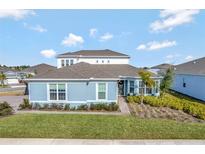 Two-story house with light blue exterior, gray roof, and landscaped lawn at 15913 Winding Bluff Dr, Montverde, FL 34756