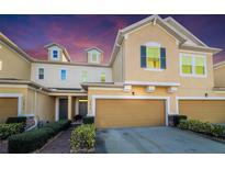 Two-story townhome with a two-car garage and landscaped walkway at 17454 Chateau Pine Way, Clermont, FL 34711