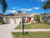 House exterior featuring a two-car garage and red front door at 2984 Cedar Glen Pl, Oviedo, FL 32765