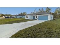 Charming one-story home featuring a blue garage door and a well-manicured lawn at 579 Marion Oaks Ln, Ocala, FL 34473