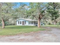 White single story home with large trees and a spacious yard at 11431 Nw 100Th St, Ocala, FL 34482