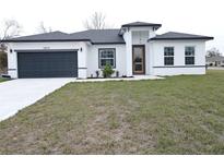 One-story house with gray roof, white walls, and a dark gray garage door at 14511 Sw 29Th Ter, Ocala, FL 34473