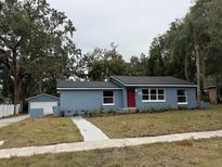 Newly renovated home with red door, gray siding, and landscaped yard at 2104 Newman St, Orlando, FL 32803