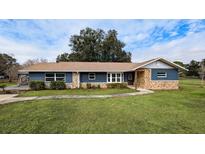 Ranch style home with stone accents and landscaped lawn at 2405 Se 157Th Lane Rd, Summerfield, FL 34491