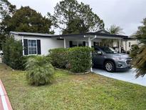 Single-wide manufactured home with carport and landscaped yard at 250 Joanne Dr, Davenport, FL 33897