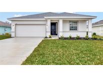 New construction home with white exterior, two-car garage, and landscaped lawn at 925 Magnolia Ave, Holly Hill, FL 32117