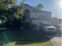 Two-story house with attached garage and landscaping at 1010 Embrun Ct, Kissimmee, FL 34759