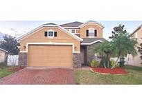 Two-story house with a large garage and well-manicured lawn at 14324 Fieldstone Lake Way, Orlando, FL 32824