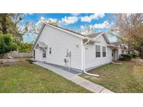 White vinyl-sided house with a red front door and landscaped yard at 1659 Rivers Edge Dr, Orlando, FL 32825