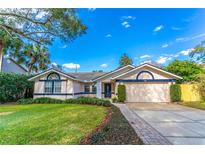 Beautiful house with a landscaped lawn, paved driveway and a two-car garage at 4491 Yachtmans Ct, Orlando, FL 32812